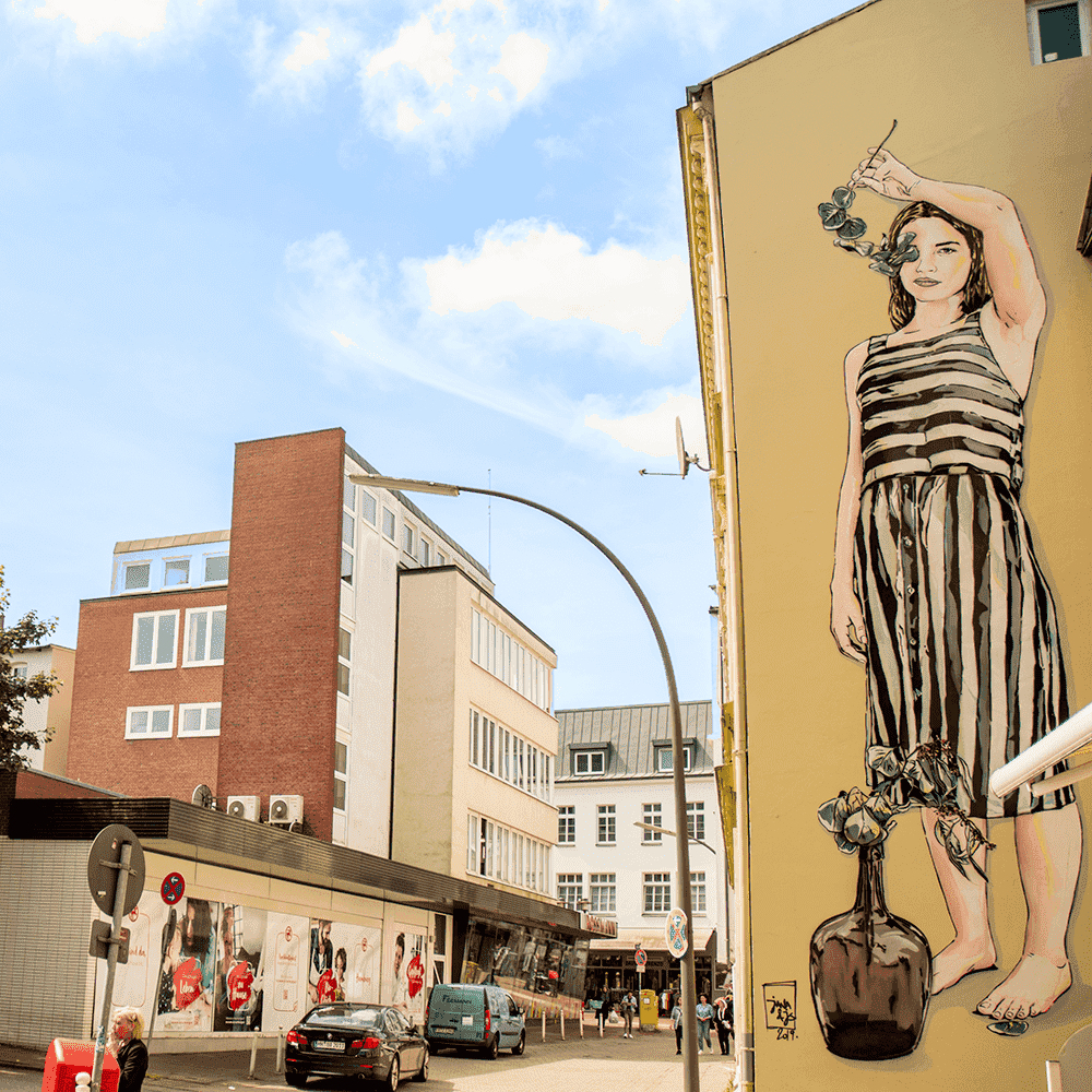 Wandgemälde einer jungen Frau auf der rückwärtigen Seite zur Lüneburger Straße in Hamburg-Harburg